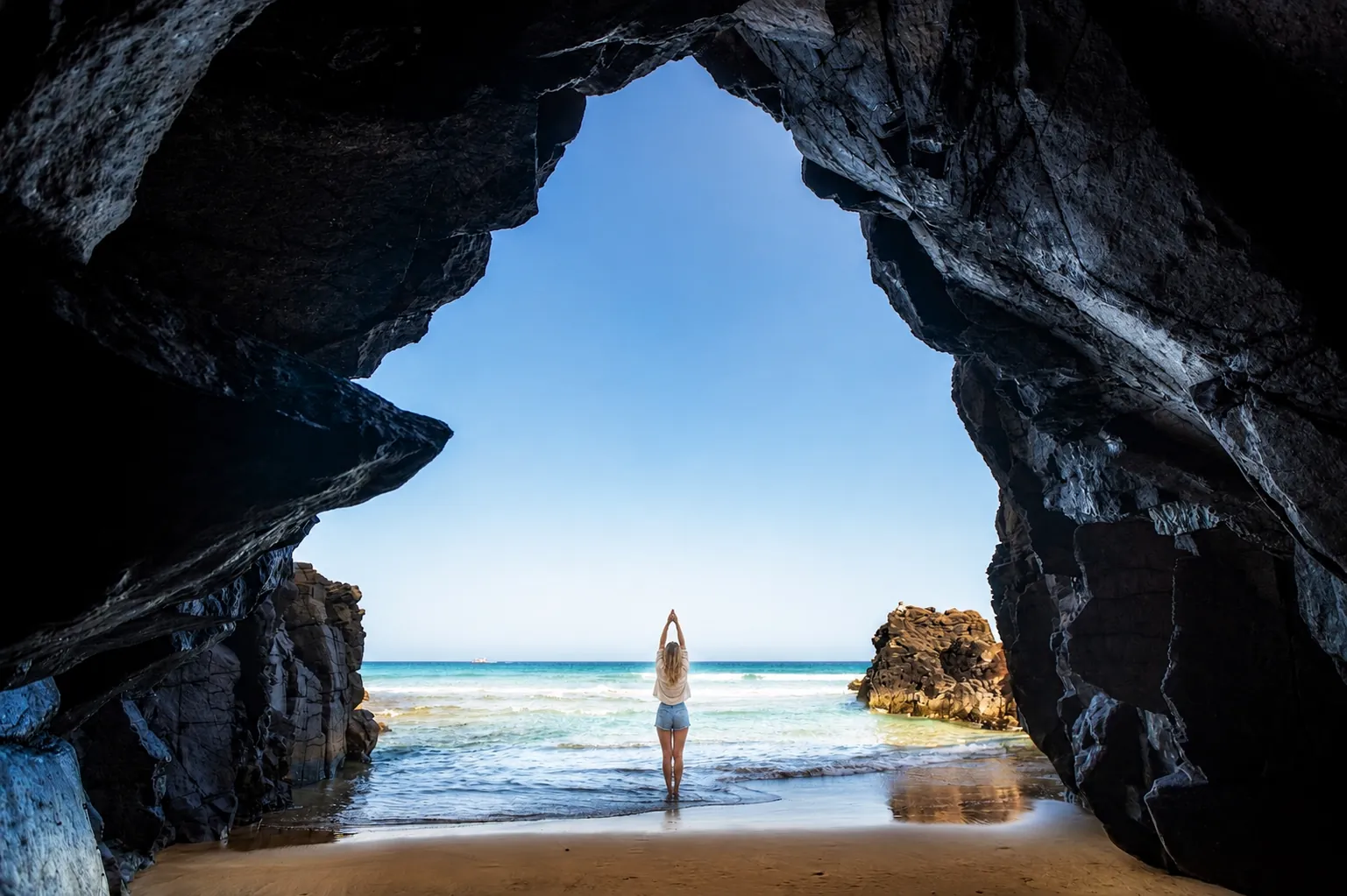 Senderista en una cueva costera de Lanzarote frente al Atlántico